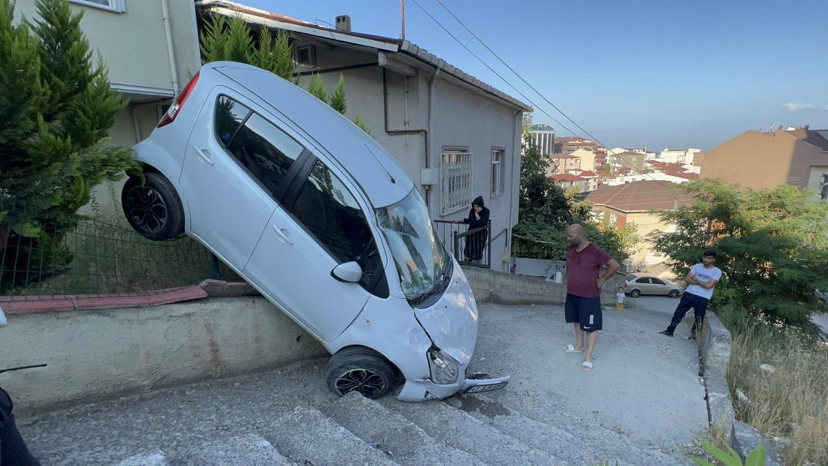 Kocaeli'de bah&ccedil;e duvarına asılı kalan otomobil vin&ccedil; yardımıyla kurtarıldı