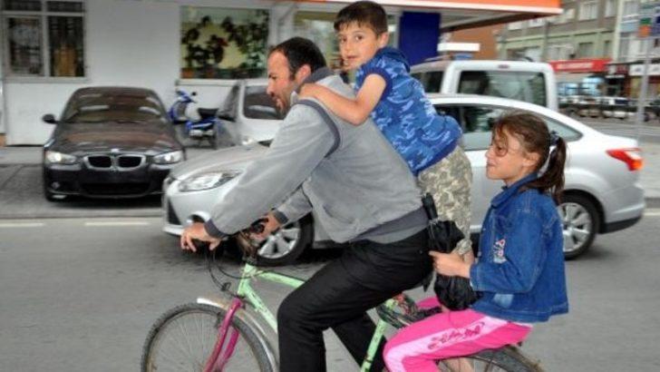 Baba ve çocuklarının bisiklette tehlikeli yolculuğu