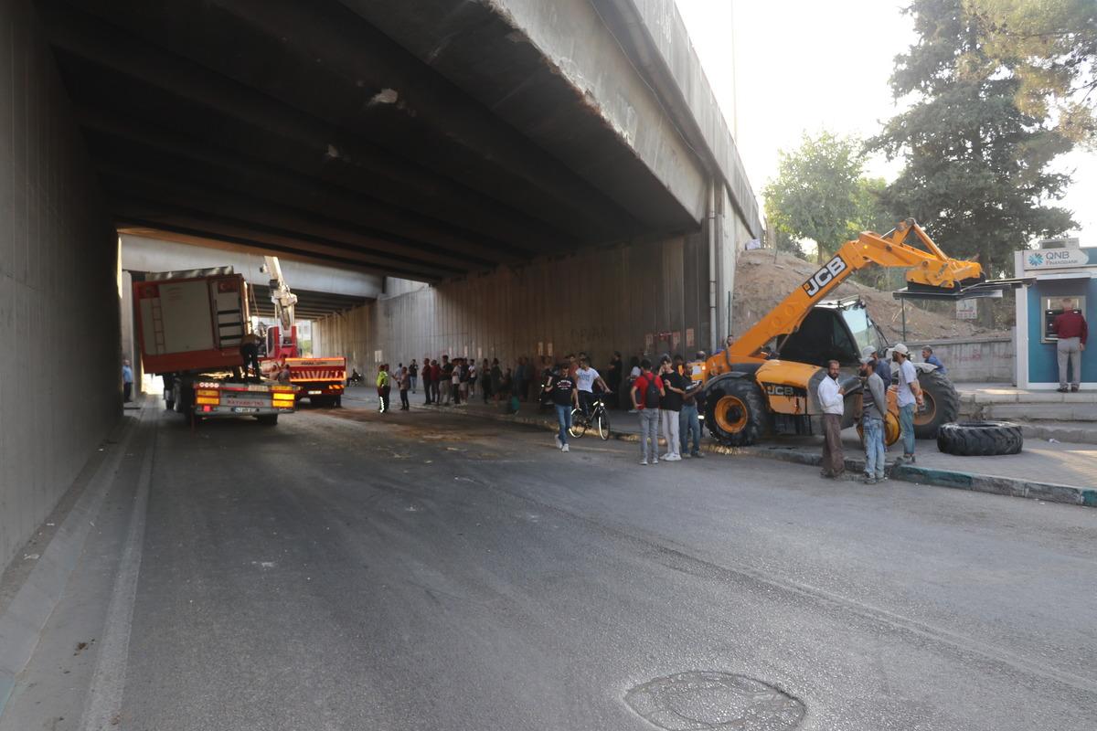 Adana'da iş makinesi ve konteyner y&uuml;kl&uuml; tır alt ge&ccedil;itte sıkıştı