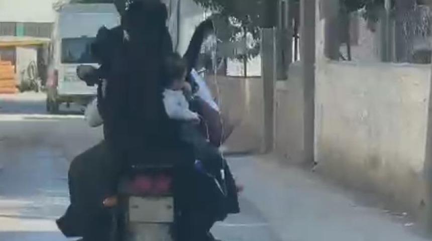 Eline serum takılı çocuğunu elektrikli bisikletle taşıdı