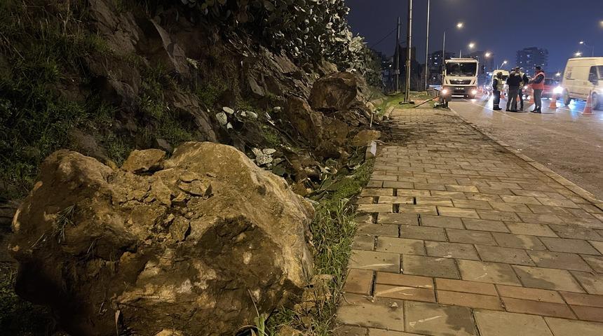 İzmir'de yağış nedeniyle koparak yola düşen kaya parçaları seyir halindeki otomobile zarar verdi