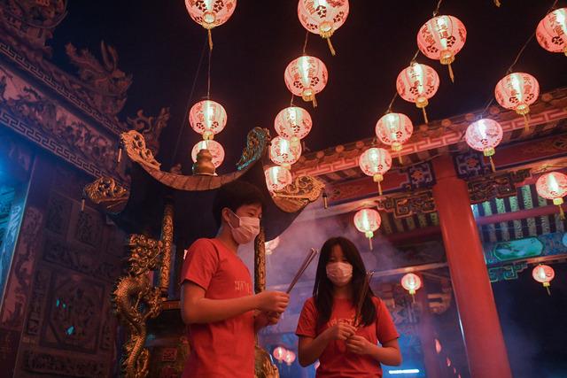 A couple makes offerings on the first day of the Lunar New Year of the Rabbit at a temple in Samut Prakan