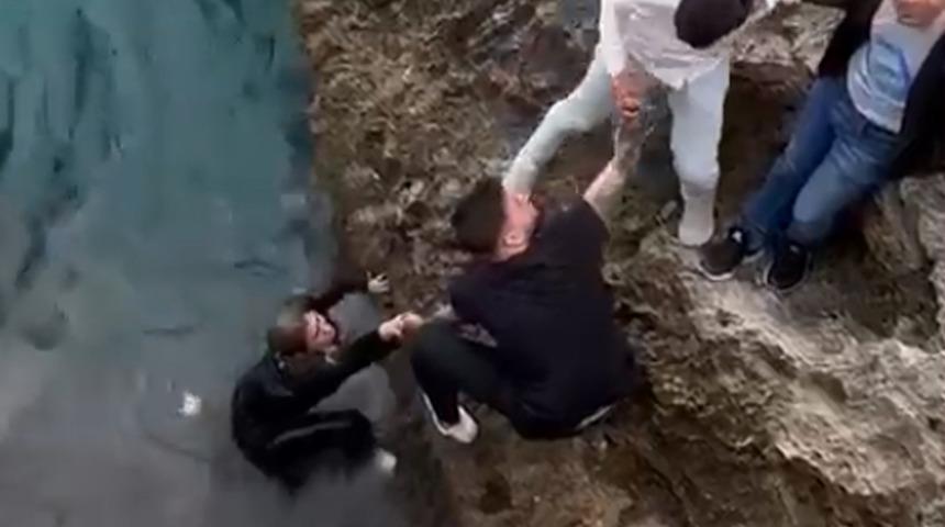 Falezden atlayan kadını el el tutuşarak kurtardılar!