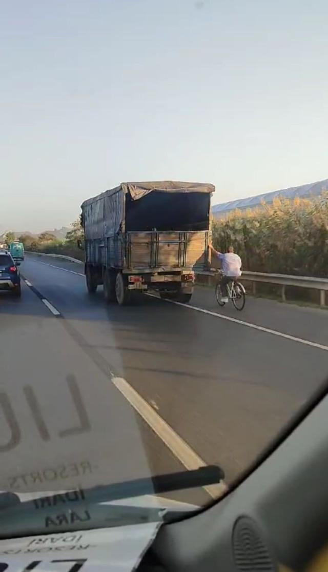 Hızla giden kamyonun arkasına tutunan bisikletli yürekleri ağza getirdi