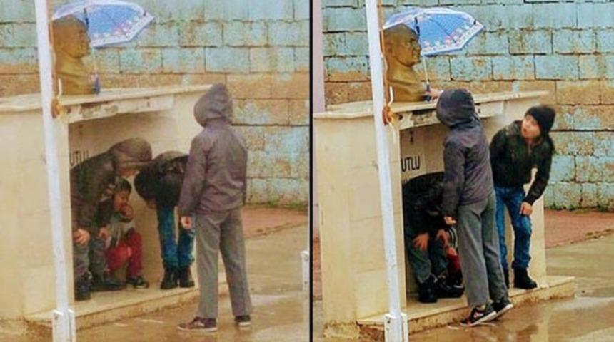 Minik &ouml;ğrenciler Atat&uuml;rk b&uuml;st&uuml; ıslanmasın diye şemsiye tuttu