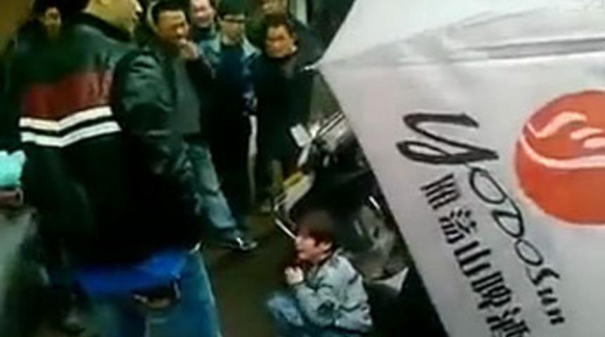 Uygurlu &ccedil;ocuğu sokak ortasında d&ouml;vd&uuml;ler