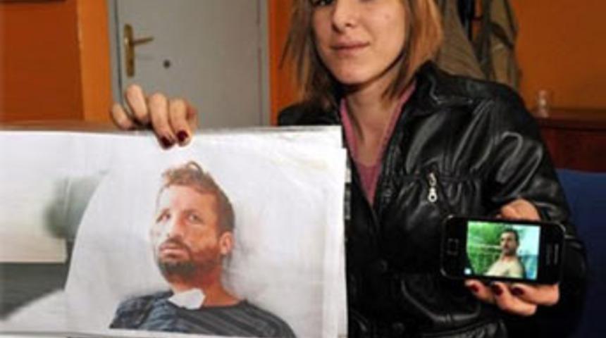 Bir elinde babasının resmi bir elinde...