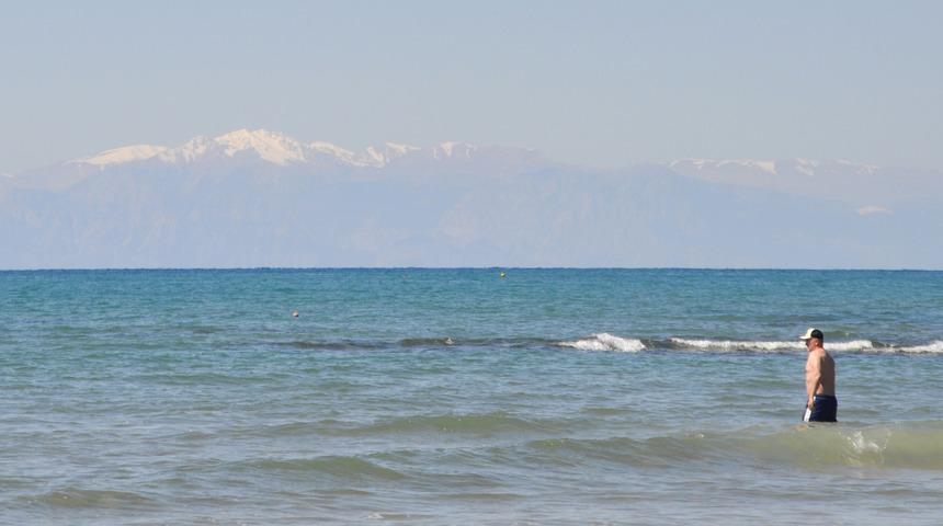 Karlı dağ manzarasında denize girdiler