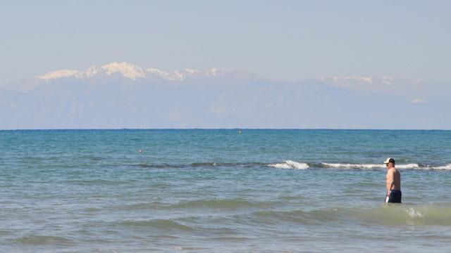 Karlı dağ manzarasında denize girdiler