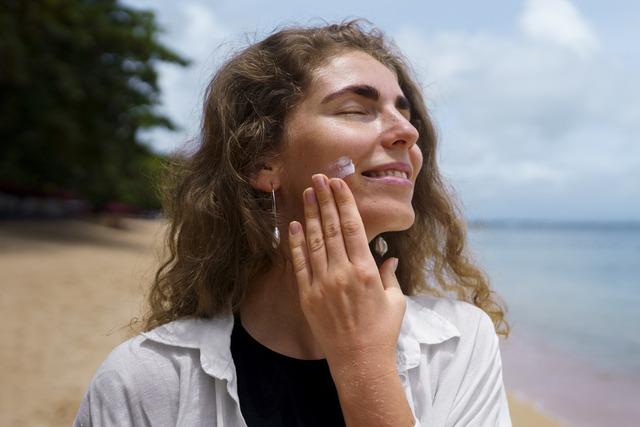 portrait-adult-woman-applying-lotion-sunburn-skin