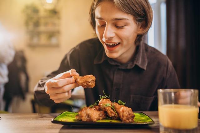 man-eating-fried-chicken-with-sauce-cafe_1303-26172