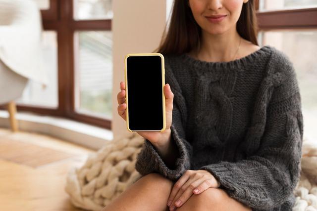 mid-shot-woman-cozy-clothes-holding-nlank-phone_23-2148717742