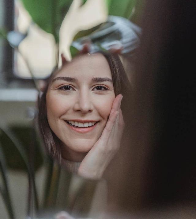 woman-smiling-looking-at-self-in-mirror