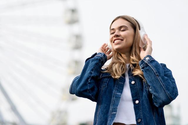 cute-blonde-girl-listening-music-ferris-wheel_23-2148648165