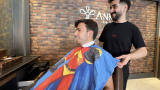 Hataylı berber müşterilerini çizgi film karakterli önlüklerle tıraş ettiği anları kaydetti