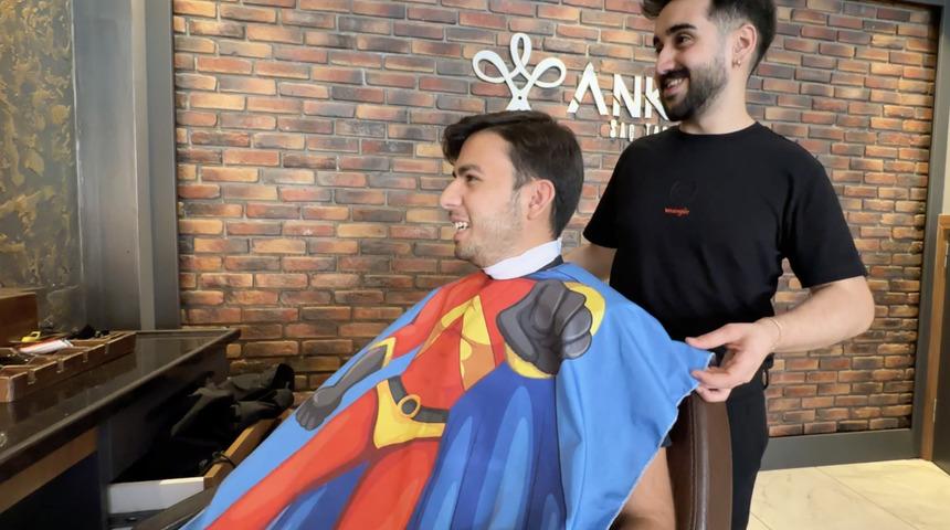 Hataylı berber müşterilerini çizgi film karakterli önlüklerle tıraş ettiği anları kaydetti