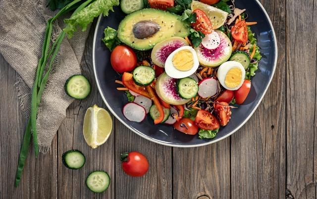 appetizing-vegetable-salad-with-eggs-avocado-wooden-background_169016-19095