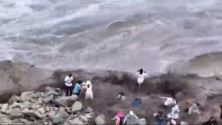 Çin'den korkutan görüntüler! Dalgalar insanları kayalıkların arasından sürükledi