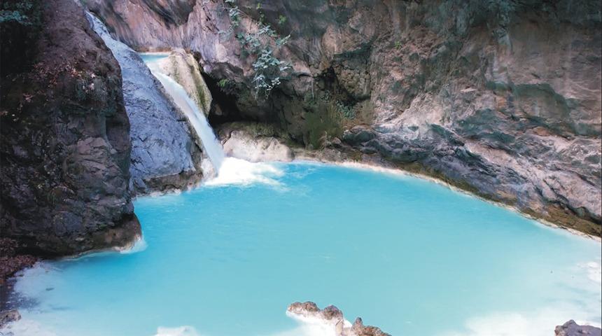 Kayaların arasından sarı ve yeşil renklere sahip ağaçların arasından uyumla akan bu şelale görenleri büyülüyor...