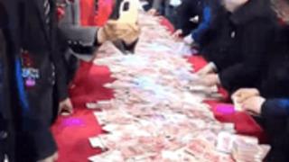 Çinli şirketin ikramiye dağıtma yöntemi çok konuşuldu! 50 metrelik masaya paraları dizdiler: En çok sayan kazandı