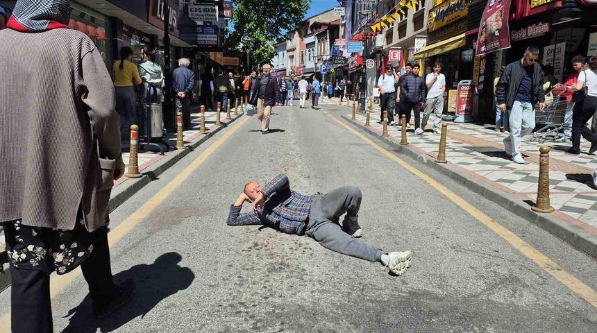 Cadde ortasında ilginç görüntüler! Araç trafiğine kapanınca yere yatıp güneşlendi...