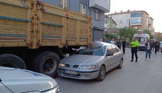 Otomobil park halindeki kamyonun altına girdi