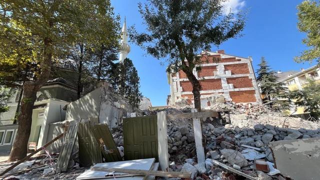 Yıkılan binanın molozları cami bahçesine döküldü