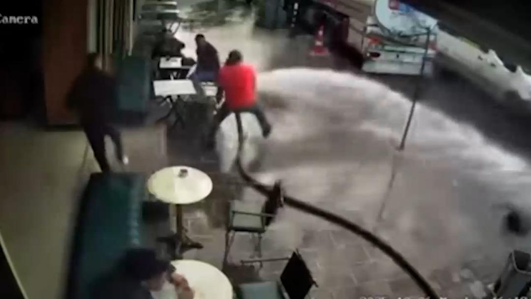 Dükkanın önünü tazyikli suyla yıkayan adam kontrolünü kaybetti! Çay içen müşterileri ıslattı 1