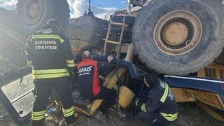 Devrilen iş makinesi altında can pazarı: Operatör güçlükle kurtarıldı