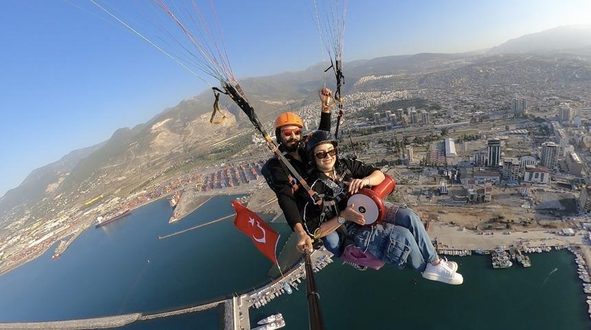 Hatay'da yamaç paraşütüyle atlayan kadın gökyüzünde darbuka çaldı