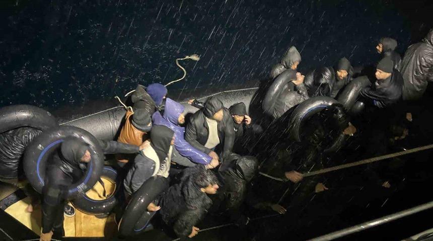 Yağmurun altında denizde s&uuml;r&uuml;klenen g&ouml;&ccedil;menlere sahil g&uuml;venlik yetişti