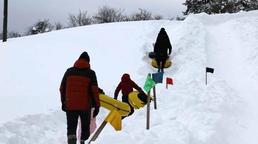 Abant&rsquo;ta k&ouml;yl&uuml;lerin hazırladığı pistte &ccedil;ocuklar şambrelle kaydı