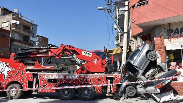 Rampada geri kayan vinç, 2 otomobili ezip, aydınlatma direği ile iş yerine çarptı