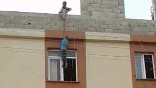 Ağızları açık bırakan görüntü! Çocuğu iple damdan sarkıttı
