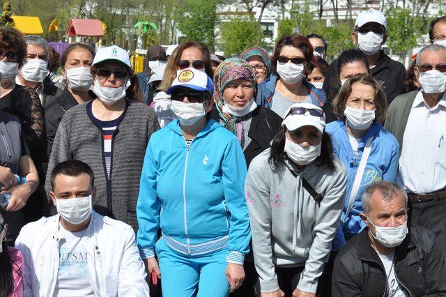 Parkta, termik santrale karşı maskeli yürüyüş