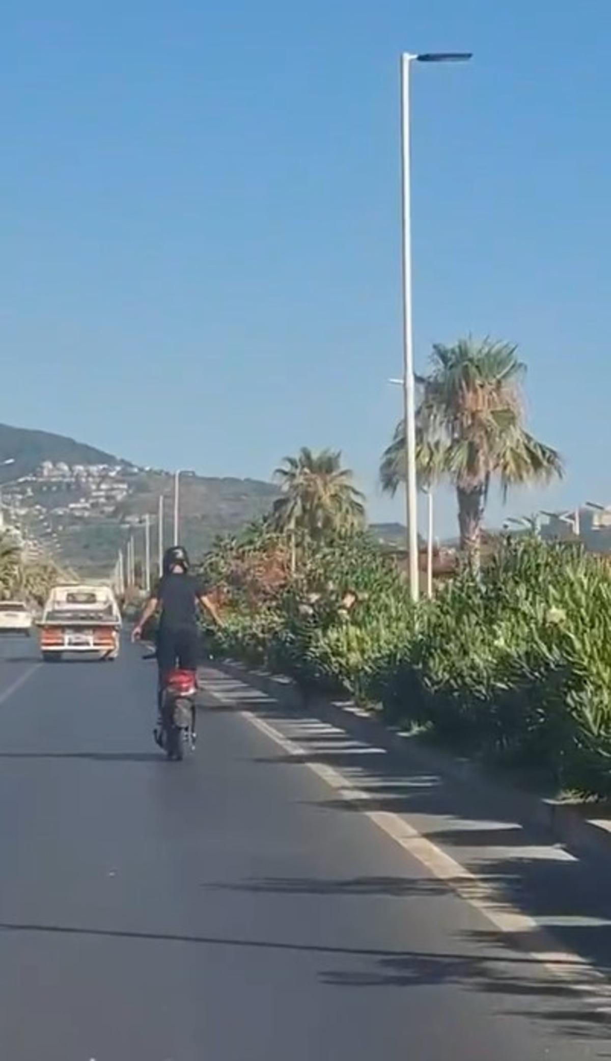 Alanya da motosiklet &uuml;zerinde ayakta ilerleyen s&uuml;r&uuml;c&uuml;n&uuml;n tehlikeli yolculuğu kamerada 3