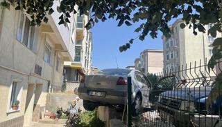 El frenini &ccedil;ekmeyi unuttu, otomobil bah&ccedil;e duvarında asılı kaldı