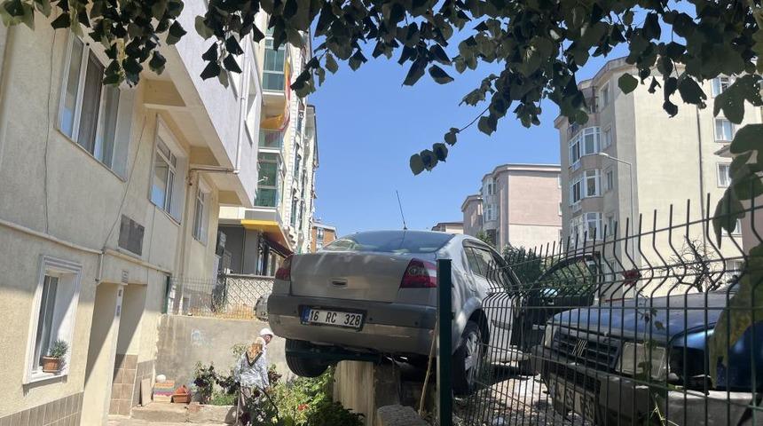 El frenini &ccedil;ekmeyi unuttu, otomobil bah&ccedil;e duvarında asılı kaldı