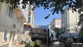 El frenini çekmeyi unuttu, otomobil bahçe duvarında asılı kaldı