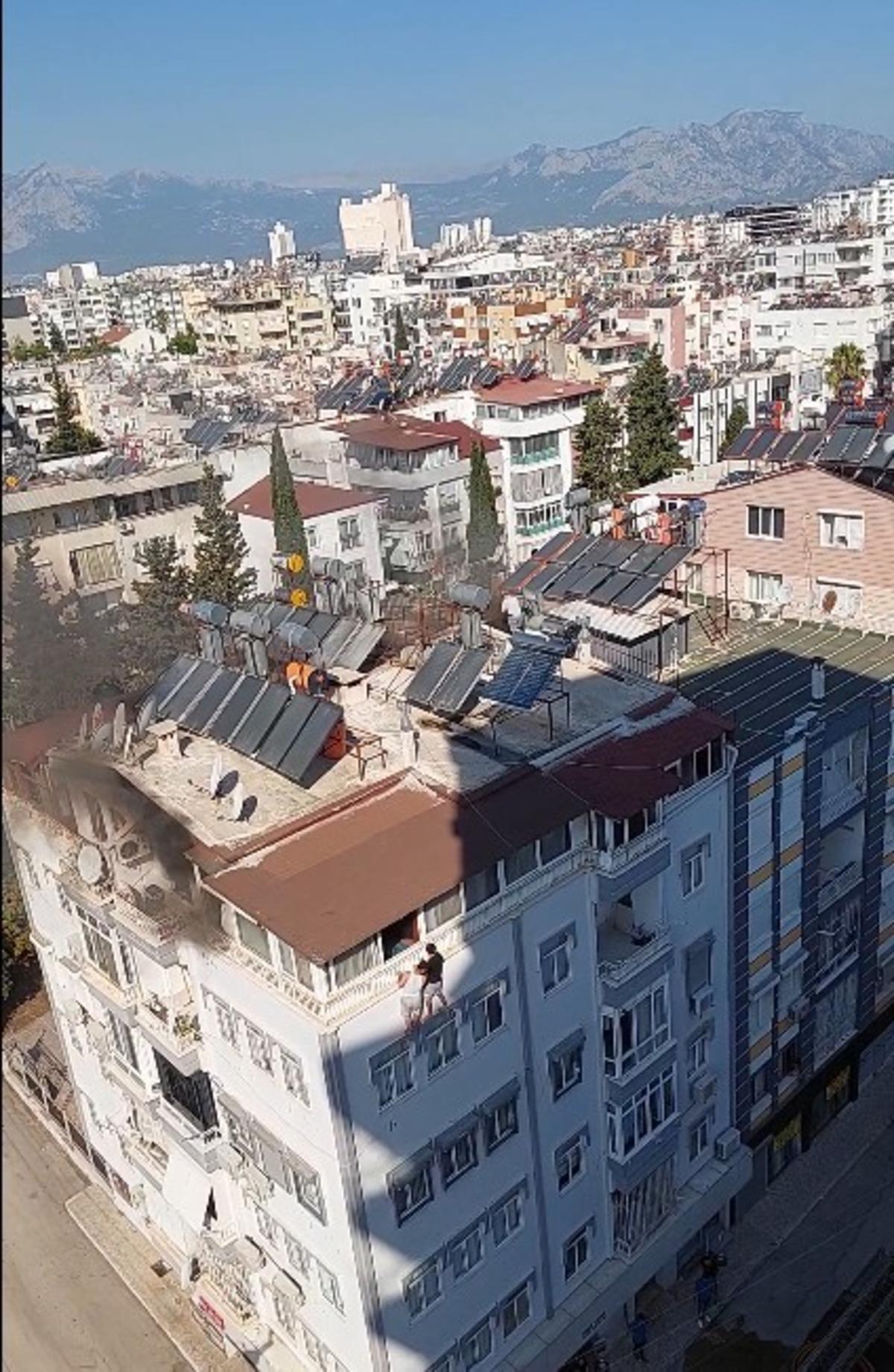 Terasta çıkan yangından kurtulmak için apartmanın duvarında asılı kaldılar 1