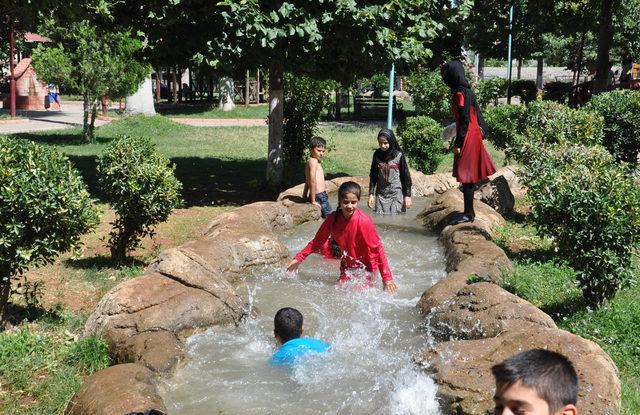 Sıcaktan bunalan çocuklar, süs havuzunda serinliyor