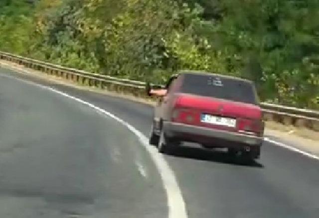 Ayaklarını camdan sarkıtarak trafiği tehlikeye attı 1