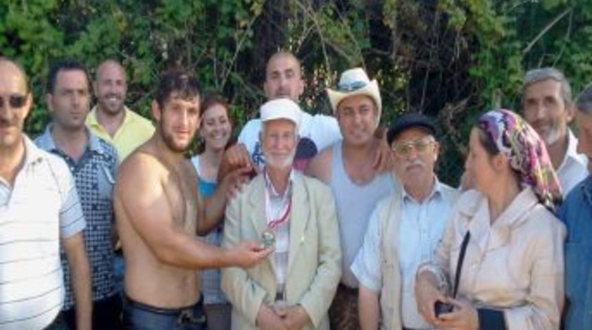 Yağlı g&uuml;reşte kazandığı madalyasını dedesine taktı