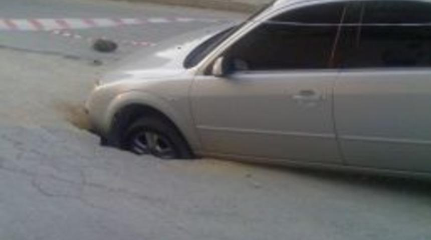 Seyir halindeki otomobil yol ortasındaki &ccedil;ukura d&uuml;şt&uuml;