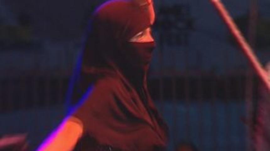 Rock konserinde kara &ccedil;arşaflı dans&ouml;z