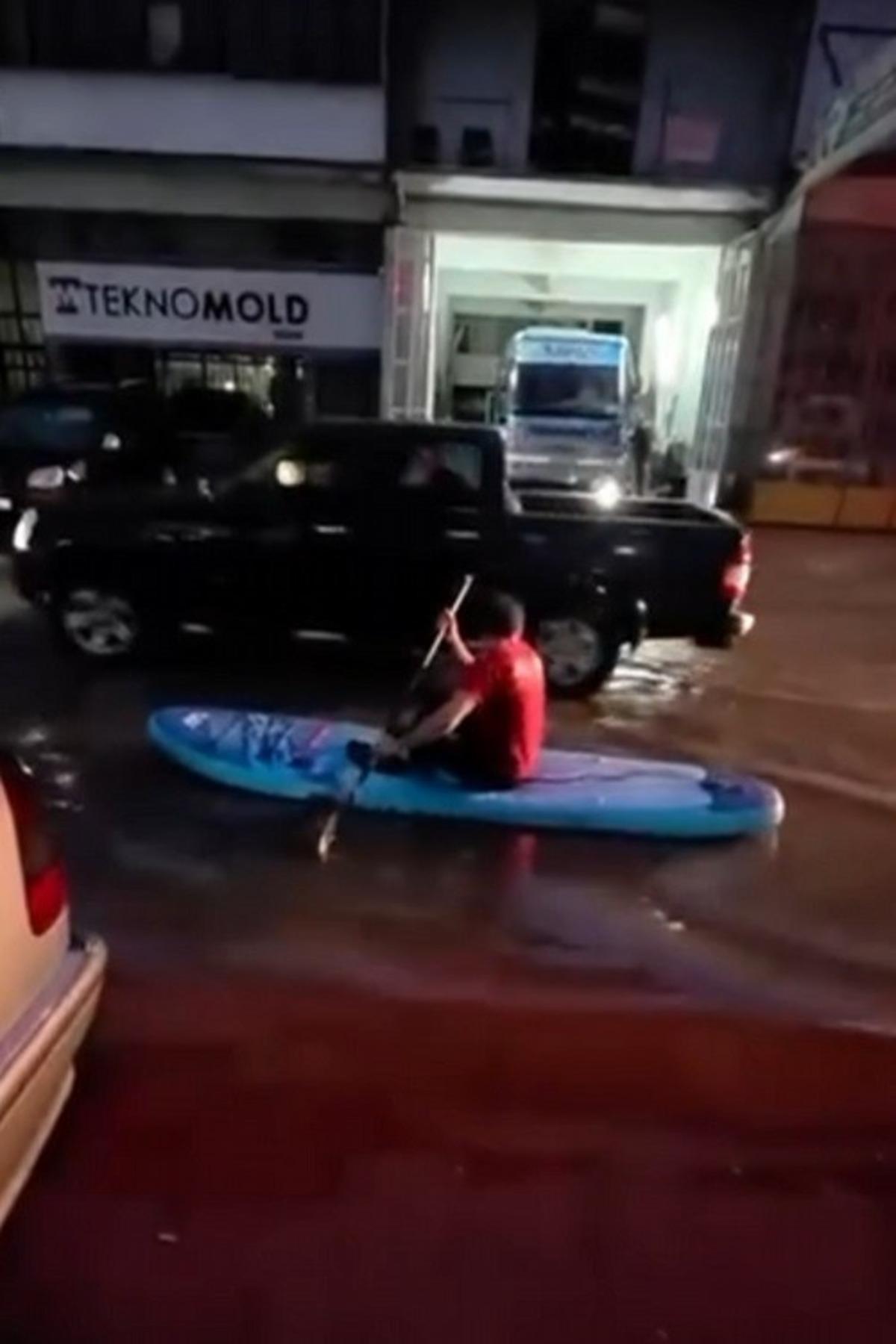 Yolları su basınca sörf tahtasını kaptı! Sokak sokak gezdi 1