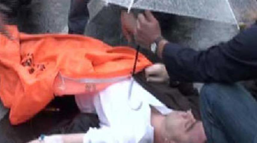 Yerde yatan yaralıya şemsiyeli koruma