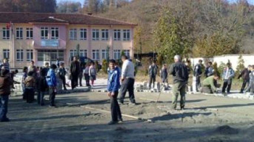 Öğrenci ve veliler parke taşı döşeyerek okul bahçesini çamurdan kurtardı