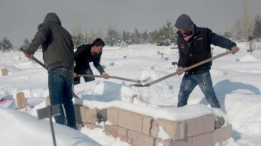 &Ccedil;ocuklar, mezarların &uuml;zerindeki karı temizleyerek okul har&ccedil;lığı &ccedil;ıkarıyor
