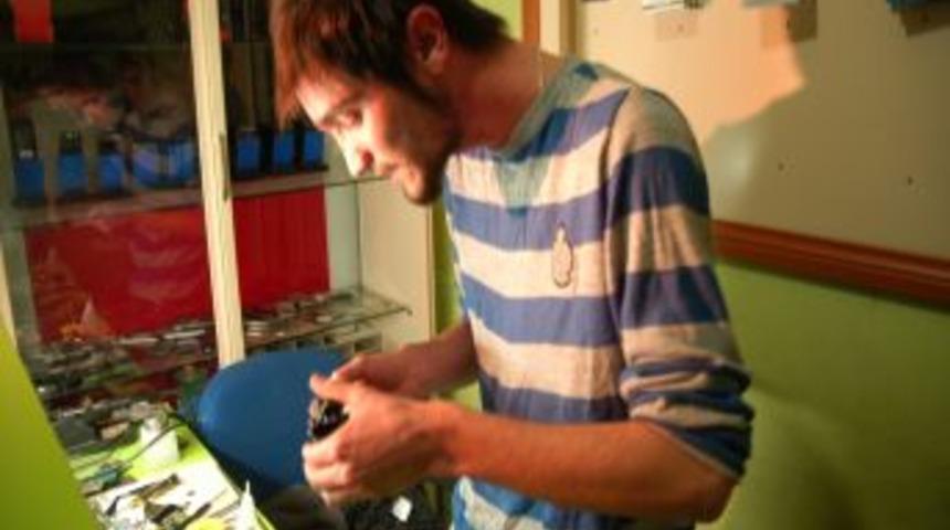 Canlı rap m&uuml;ziği eşliğinde cep telefonu tamir ediyor